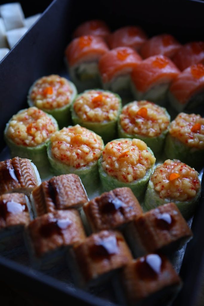 Close-up of a diverse sushi platter featuring vibrant toppings and textures.